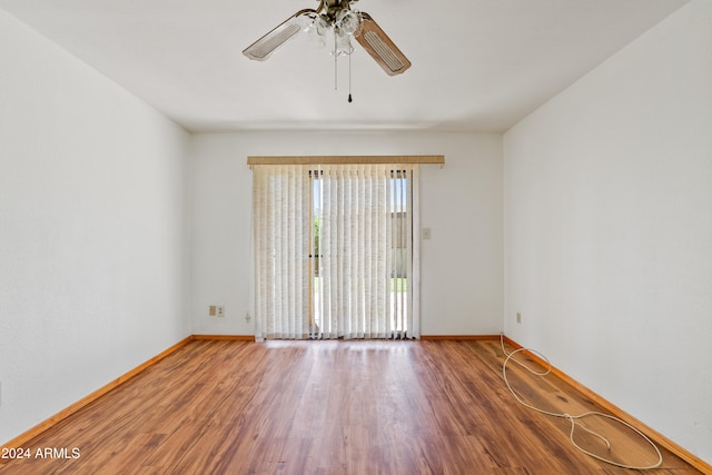 spare room with a ceiling fan, baseboards, and wood finished floors