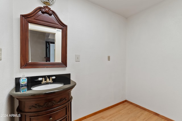 bathroom featuring vanity, baseboards, and wood finished floors