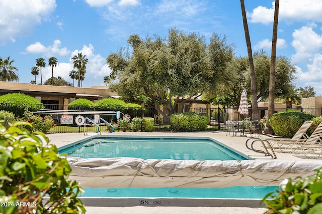 pool with fence and a patio