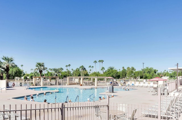 community pool with a patio area and fence