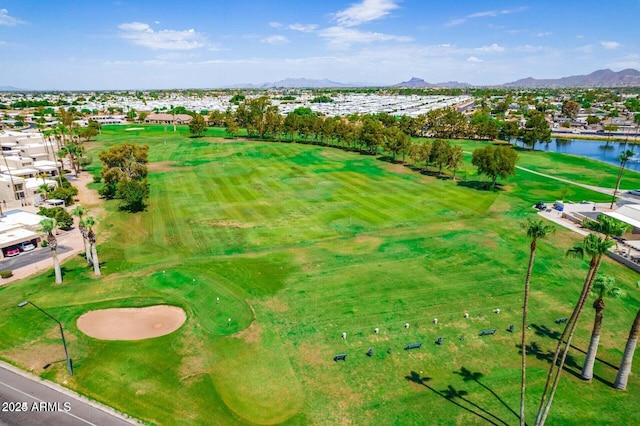 drone / aerial view with view of golf course and a water and mountain view