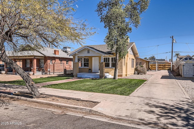 view of front of home featuring stucco siding, a fenced front yard, and a front yard