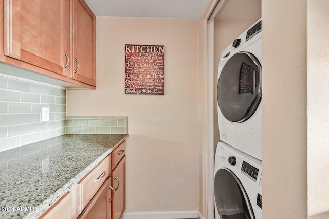 clothes washing area featuring stacked washer / drying machine