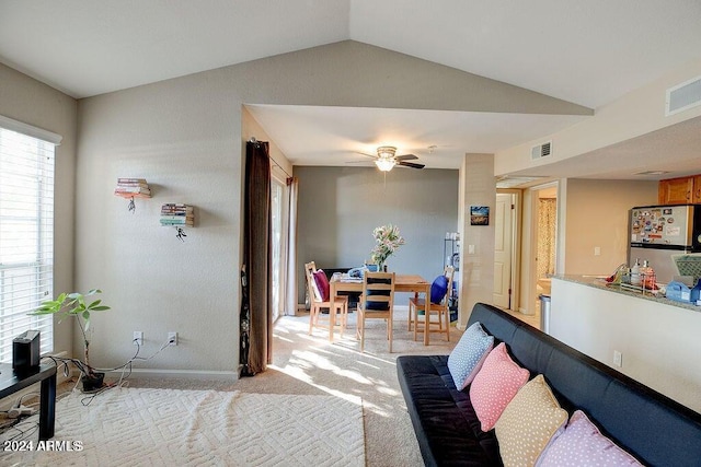 bedroom featuring stainless steel refrigerator, vaulted ceiling, and light colored carpet