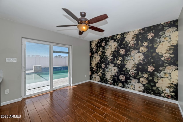 unfurnished room with baseboards, ceiling fan, wood finished floors, and wallpapered walls