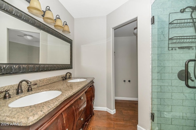 full bath featuring a stall shower, wood finished floors, and a sink