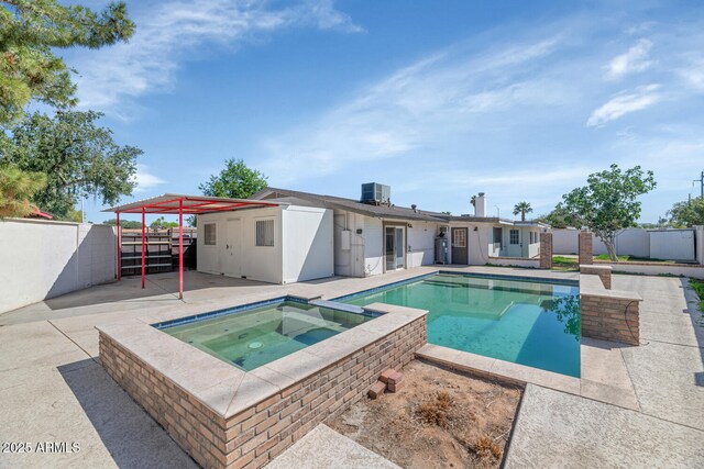 view of pool with central AC unit, a fenced backyard, a pool with connected hot tub, and a patio