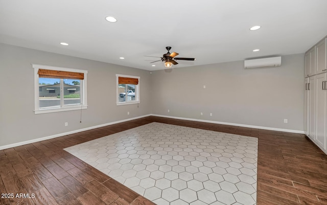 empty room featuring a wall unit AC, ceiling fan, dark wood-style floors, and recessed lighting