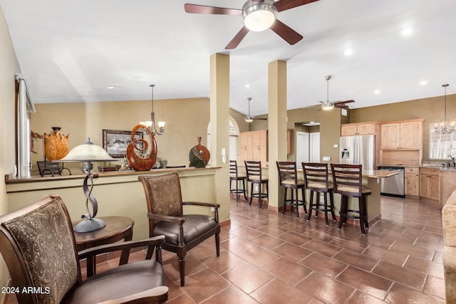 living room featuring ceiling fan with notable chandelier, lofted ceiling, and sink