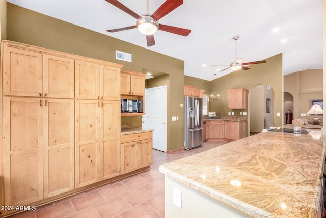 kitchen featuring ceiling fan, light brown cabinets, lofted ceiling, and stainless steel fridge