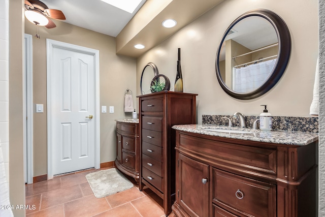 bathroom featuring ceiling fan, a skylight, and vanity