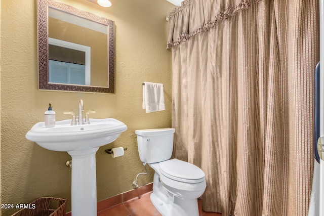 bathroom with toilet and tile patterned floors