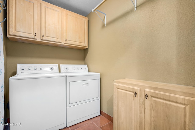 washroom with cabinets, light tile patterned floors, and washing machine and dryer