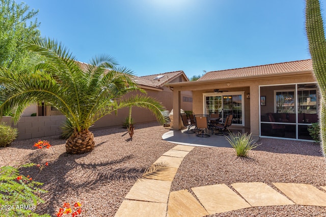 back of property with ceiling fan and a patio area