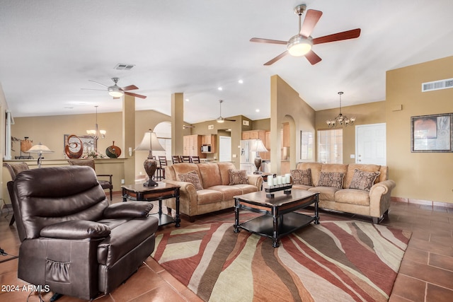 living room featuring ceiling fan with notable chandelier, lofted ceiling, and dark tile patterned floors