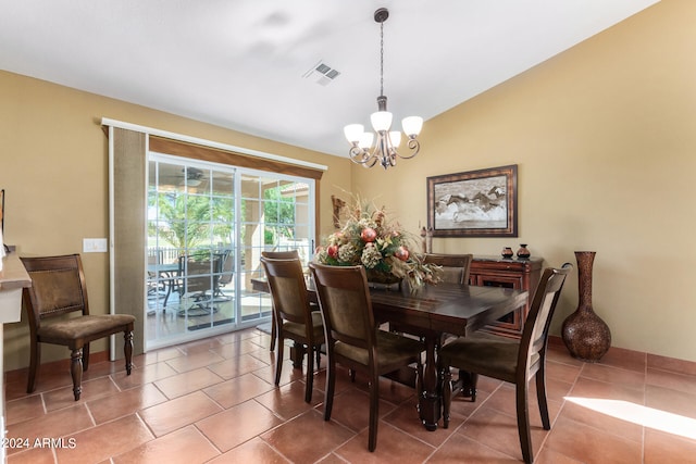 dining room with a notable chandelier, lofted ceiling, and tile patterned flooring