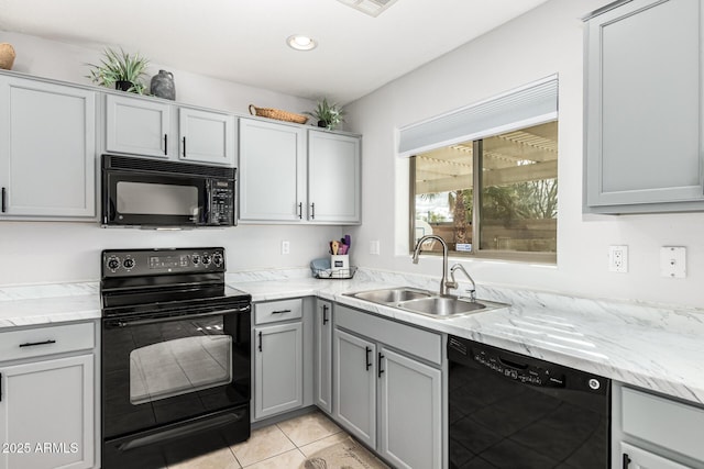 kitchen with black appliances, gray cabinets, a sink, light tile patterned floors, and light stone countertops