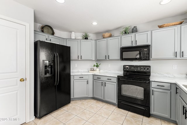 kitchen featuring black appliances, gray cabinetry, light stone counters, recessed lighting, and light tile patterned floors