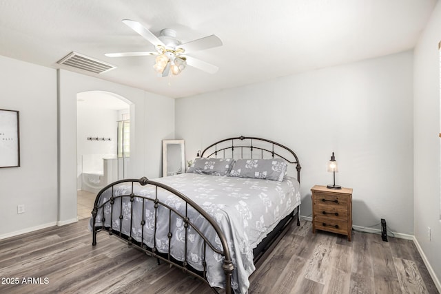 bedroom featuring visible vents, ceiling fan, baseboards, wood finished floors, and arched walkways