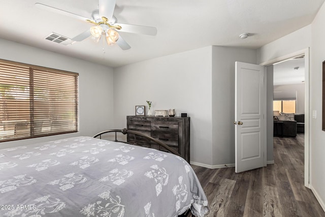 bedroom with visible vents, a ceiling fan, baseboards, and wood finished floors