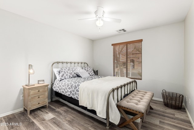 bedroom featuring a ceiling fan, visible vents, wood finished floors, and baseboards