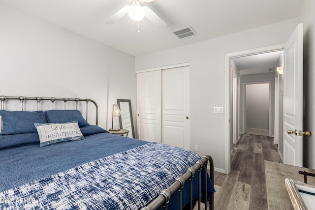 bedroom featuring visible vents, wood finished floors, a closet, baseboards, and ceiling fan