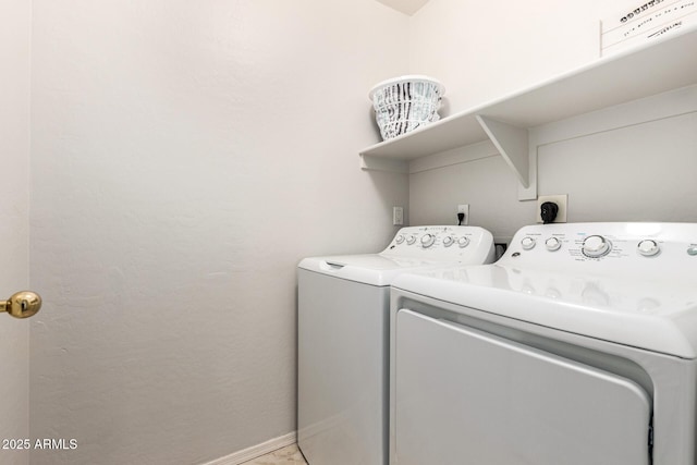 clothes washing area featuring laundry area, washing machine and dryer, and baseboards