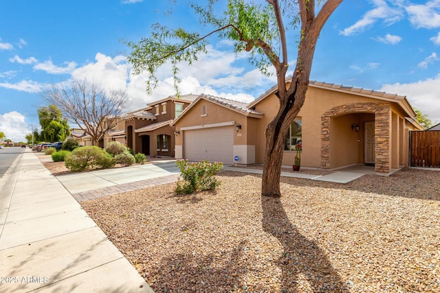 mediterranean / spanish-style home featuring fence, a tiled roof, stucco siding, driveway, and an attached garage