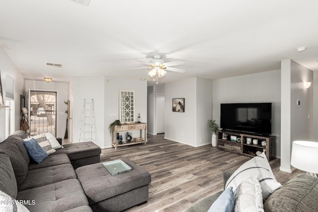 living area featuring ceiling fan, visible vents, baseboards, and wood finished floors