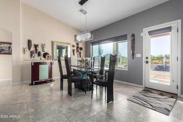 dining space featuring lofted ceiling and tile floors