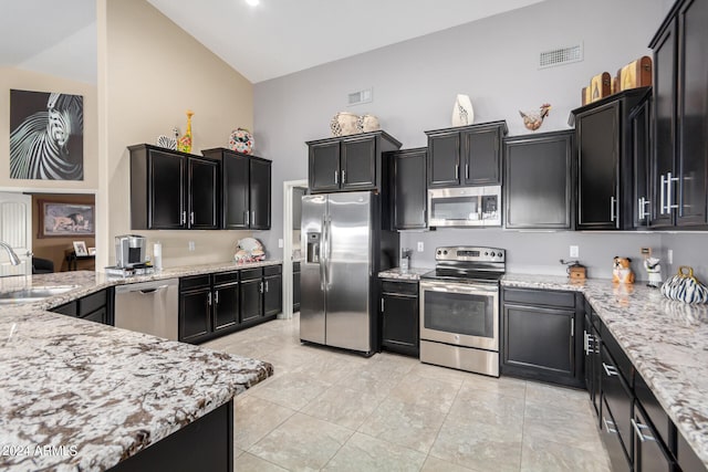 kitchen featuring high vaulted ceiling, stainless steel appliances, sink, and light tile floors