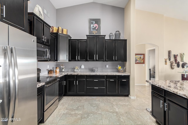 kitchen featuring appliances with stainless steel finishes, high vaulted ceiling, light stone countertops, and light tile floors