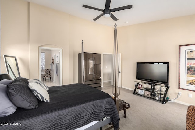 carpeted bedroom featuring ceiling fan and a towering ceiling