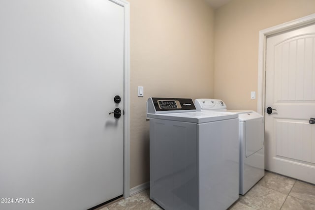 laundry room featuring separate washer and dryer and light tile floors