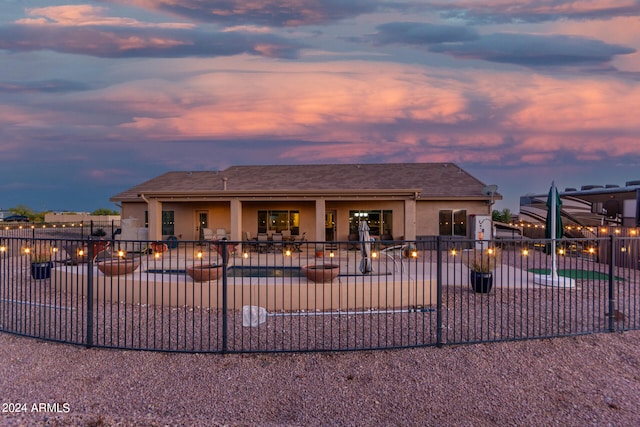 view of front of property with a patio and a fenced in pool