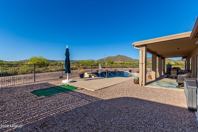 view of yard featuring a patio area, a mountain view, and a fenced in pool