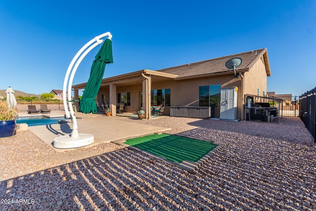 back of property featuring a patio area and a fenced in pool