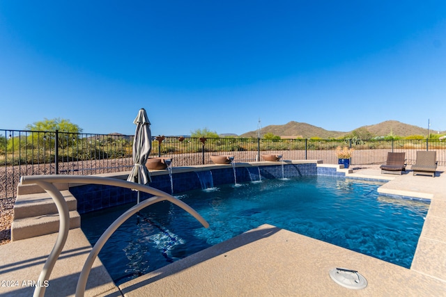 view of swimming pool with a mountain view, pool water feature, and a patio