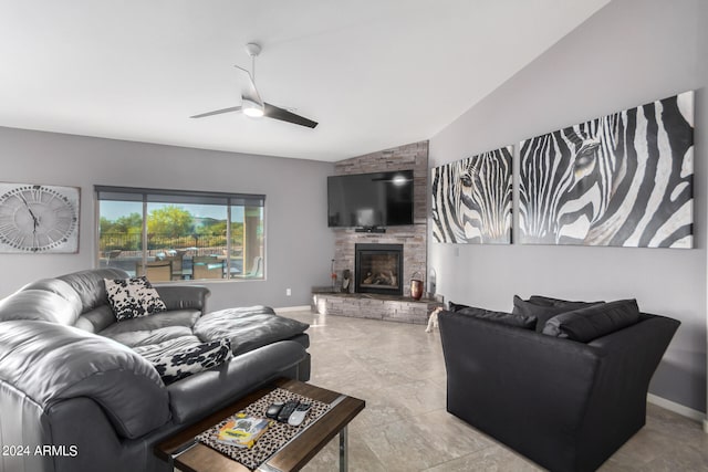 tiled living room with vaulted ceiling, ceiling fan, and a stone fireplace