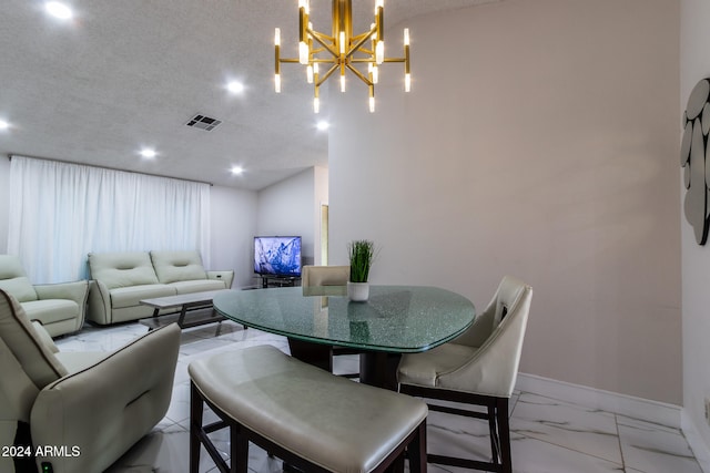 dining area with a textured ceiling and an inviting chandelier