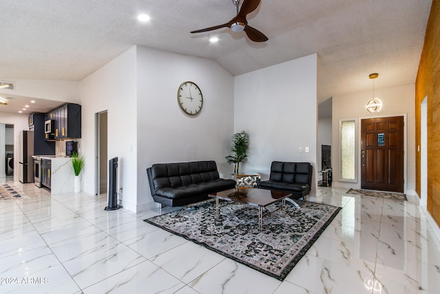 living room with lofted ceiling, a textured ceiling, and ceiling fan