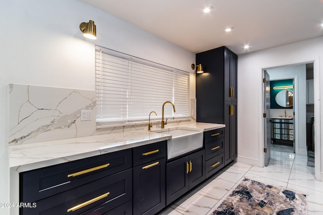 kitchen featuring sink and light stone countertops