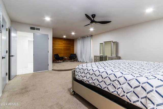 carpeted bedroom with wood walls and ceiling fan