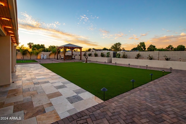 yard at dusk with a patio and a gazebo