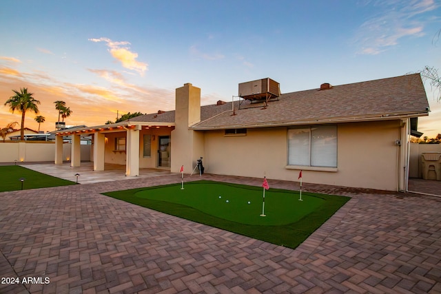 back house at dusk with a patio area