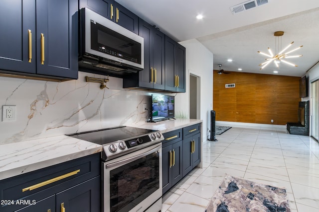 kitchen with blue cabinetry, decorative backsplash, stainless steel appliances, and wooden walls