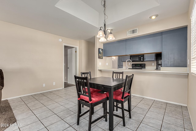 tiled dining room with sink and an inviting chandelier