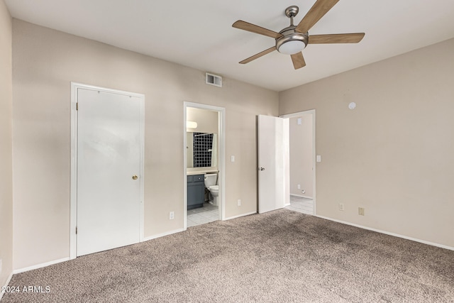 unfurnished bedroom featuring ceiling fan, ensuite bath, light carpet, and a closet