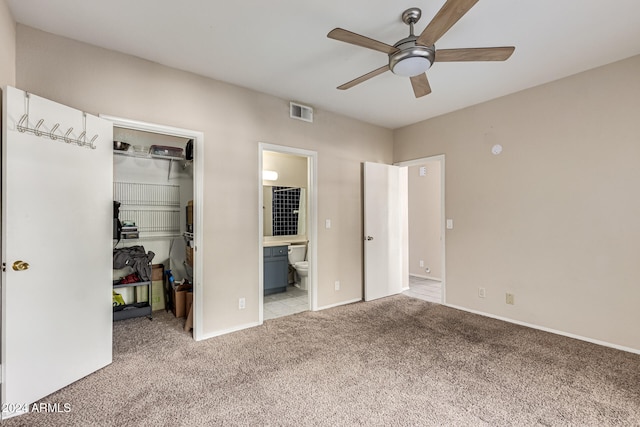 unfurnished bedroom with connected bathroom, a closet, light carpet, and ceiling fan