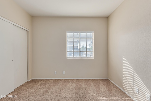 unfurnished bedroom featuring light carpet and a closet